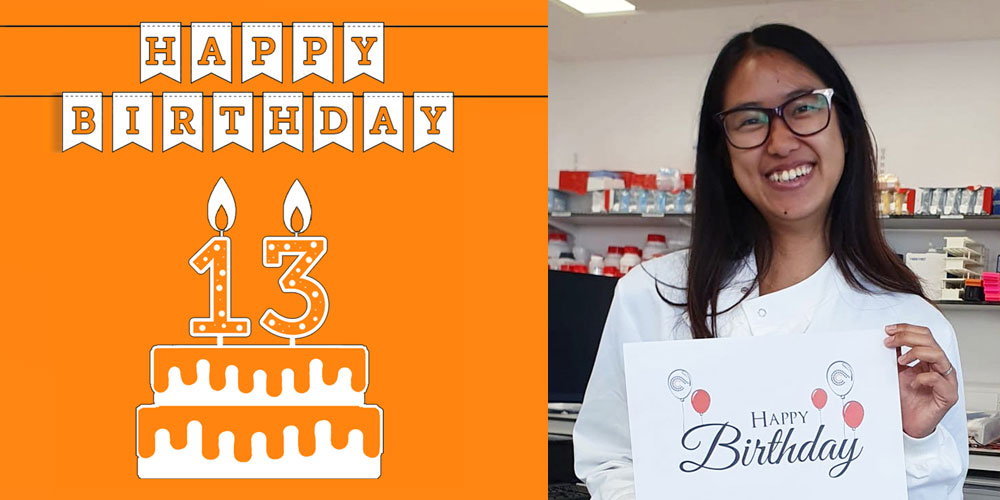 2 scientists holding birthday signs