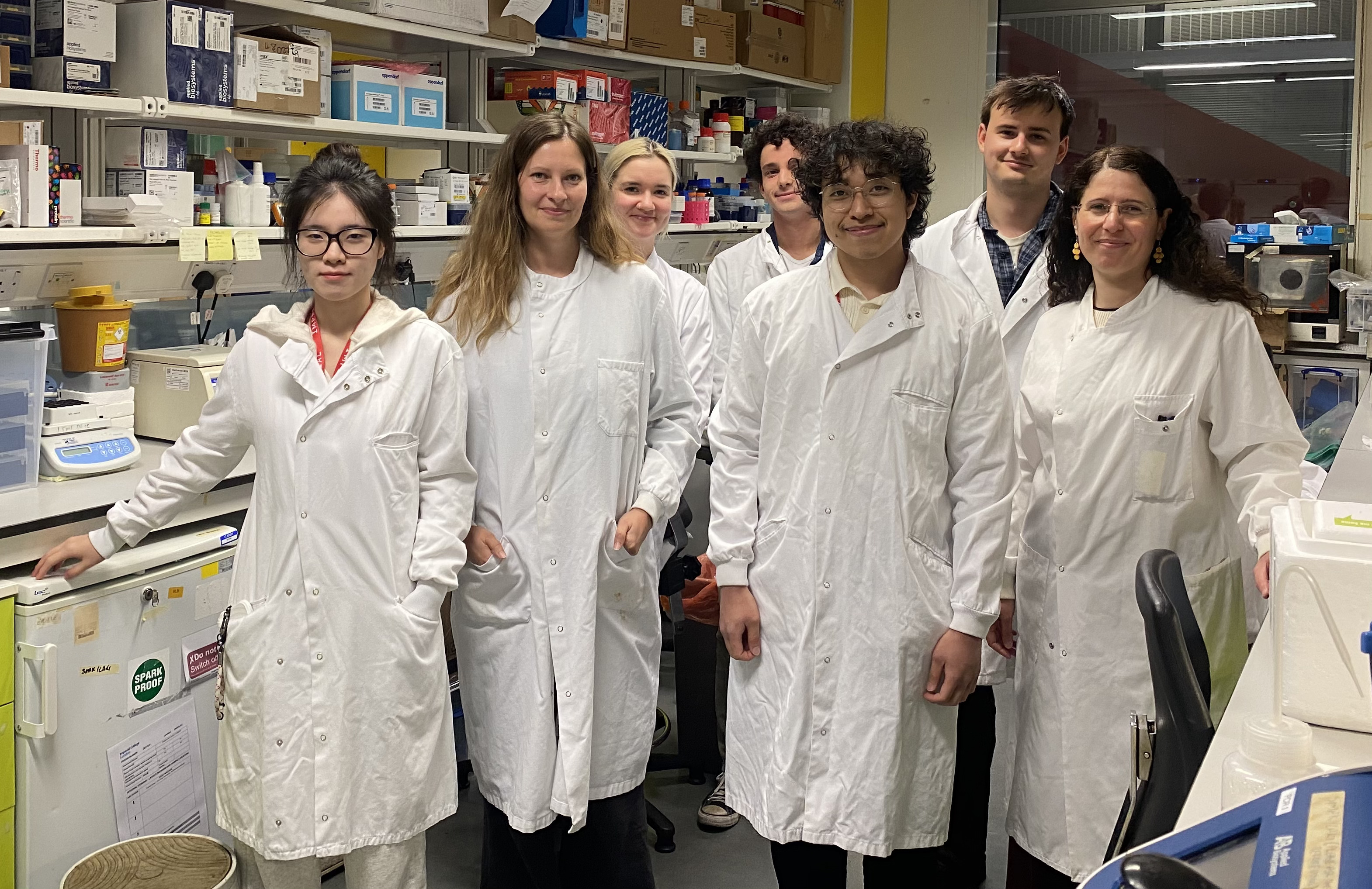 6 people smiling at camera in lab coats